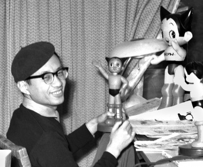 Osamu Tezuka posant avec une figurine d'Astro Boy