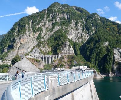 Barrage de Kurobe, portion de route piétonne sur le remblai et vue sur l'ouvrage