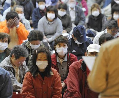 © Kyodo News (avril 2011), habitants du village de Iitate rassemblés pour la mise en place de leur évacuation