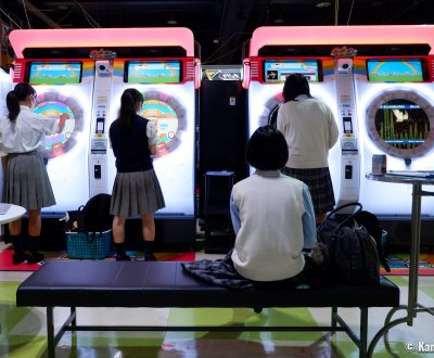 Jeunes japonaises sur des bornes de jeux dans une salle d'arcade (Game Center) à Tokyo