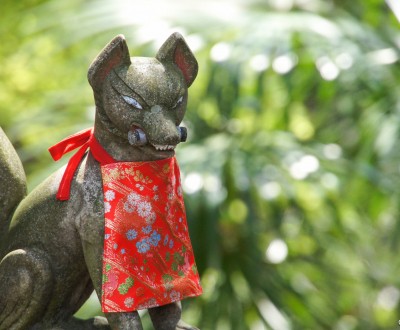 Statue du renard Inari tenant un rouleau dans la gueule