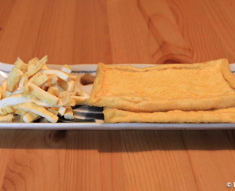 Tofu frit Aburaage coupé en morceaux et en tranches dans une assiette