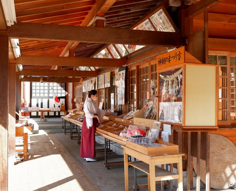 Morioka Hachiman-gu, prêtresse shinto Miko devant le comptoir aux amulettes