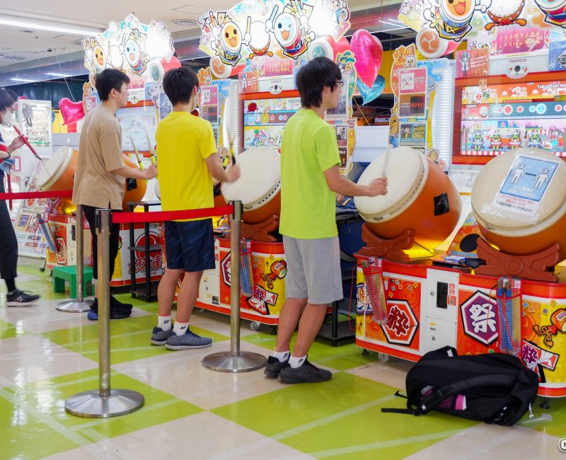Jeunes japonais sur des bornes de jeux musicaux (tambour Taiko no Tatsujin) dans une salle d'arcade (Game Center) à Tokyo Jeunes japonais sur des bornes de jeux musicaux (tambour Taiko no Tatsujin) dans une salle d'arcade (Game Center) à Tokyo