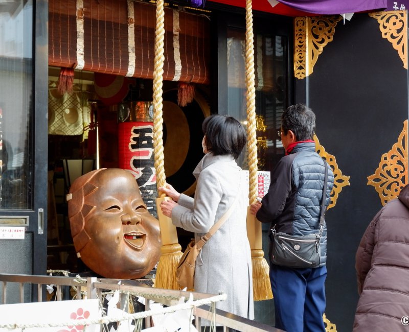 Asakusa Otori-jinja (Tokyo), fidèles en train de prier devant le masque de la déesse Okame Asakusa Otori-jinja (Tokyo), fidèles en train de prier devant le masque de la déesse Okame