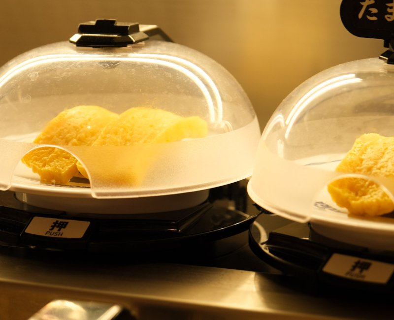 Kura Sushi, Global Flagship Store Oshiage Station (Tokyo Skytree), assiettes de sushi Tamagoyaki avec cloche antibactérienne Kura Sushi, Global Flagship Store Oshiage Station (Tokyo Skytree), assiettes de sushi Tamagoyaki avec cloche antibactérienne