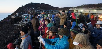 Ascension du Mont Fuji, randonneurs qui contemplent le lever de soleil au sommet du Fuji-san