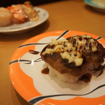 Sushi hamburger à la viande dans un restaurant kaiten-zushi