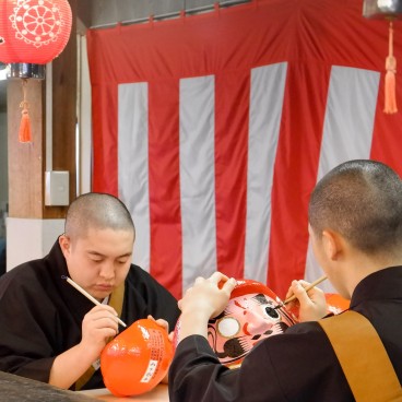 Myoho-ji (Fuji City), moines en train de peindre un œil de Daruma pendant le festival Bishamonten Taisai