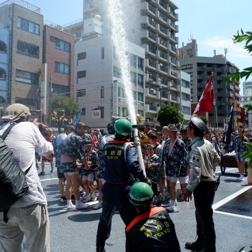 Fukagawa Hachiman Matsuri, pompiers de Tokyo et policier aspergeant d'eau les participants