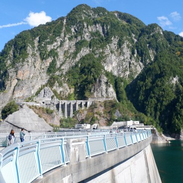 Barrage de Kurobe, portion de route piétonne sur le remblai et vue sur l'ouvrage