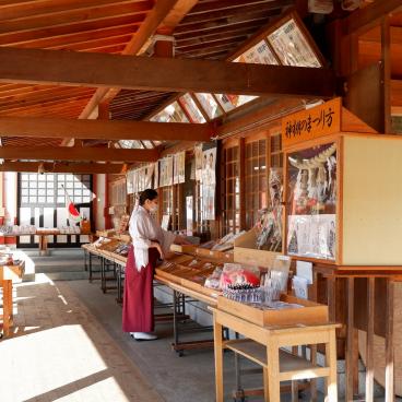 Morioka Hachiman-gu, prêtresse shinto Miko devant le comptoir aux amulettes