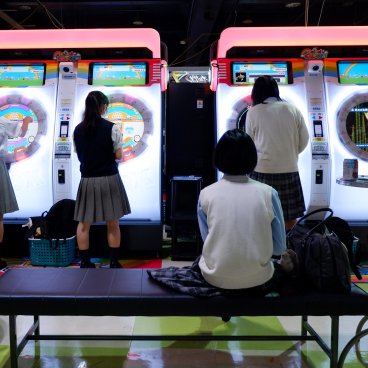 Jeunes japonaises sur des bornes de jeux musicaux (Maimai DX) dans une salle d'arcade (Game Center) à Tokyo