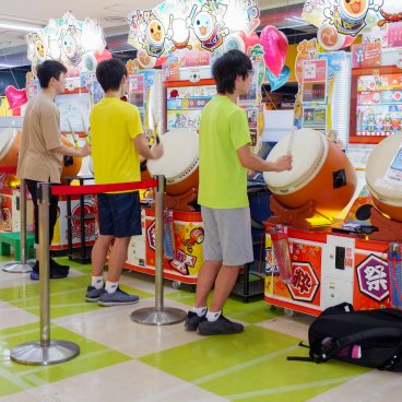 Jeunes japonais sur des bornes de jeux musicaux (tambour Taiko no Tatsujin) dans une salle d'arcade (Game Center) à Tokyo