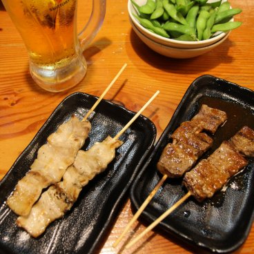 Torikizoku Shinjuku Kuyakusho-dori (Tokyo), assortiment de brochettes Yakitori, fèves Edamame et bière japonaise