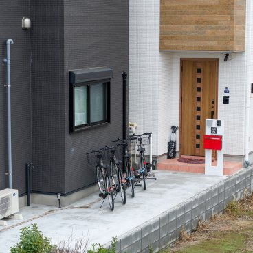 Ici Japon Village (Tokyo), entrée de la maison B et vélos à disposition des locataires des hôtels