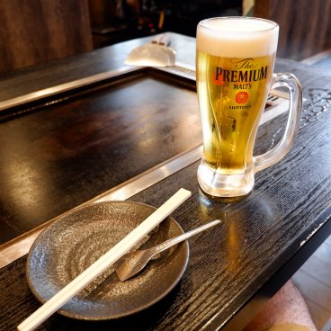 Tsukishima Monja Street (Tokyo), table avec plaque de cuisson dans un restaurant de monjayaki