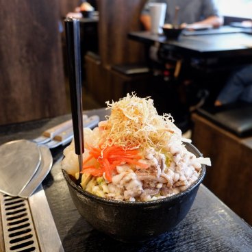 Tsukishima Monja Street (Tokyo), garniture de monjayaki à cuire sur plaque dans un restaurant