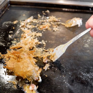 Tsukishima Monja Street (Tokyo), reste de l'appareil à monjayaki grillé à manger