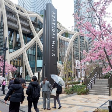 Azabudai Hills (Tokyo), entrée du complexe et cerisiers Kawazu-zakura en fleurs