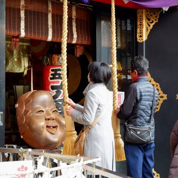 Asakusa Otori-jinja (Tokyo), fidèles en train de prier devant le masque de la déesse Okame