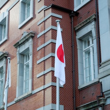 Gare de Tokyo (Tokyo), drapeau du Japon devant le bâtiment en briques Marunouchi