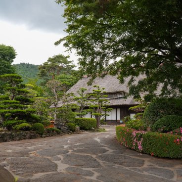Oshino Hakkai (Fujiyoshida), Plantations de pins et d'azalées dans le jardin d'une maison à toit de chaume